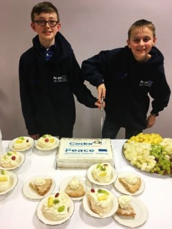 Two children cutting celebration cake.